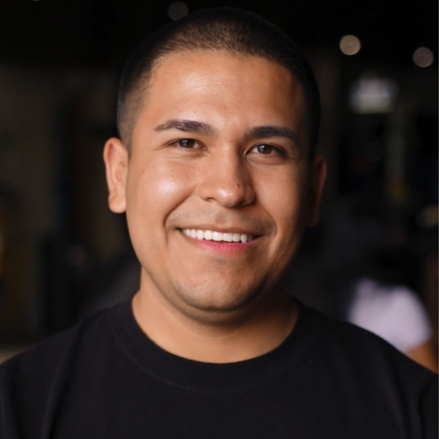 A man in a black shirt smiles at the camera.