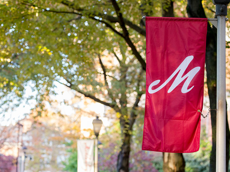 Closeup image of Muhlenberg College red flag with large white letter 