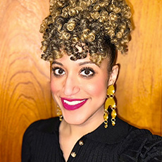 Profile image of Assistant Professor of English and Africana Studies, Emanuela Kucik wearing black button-up shirt.