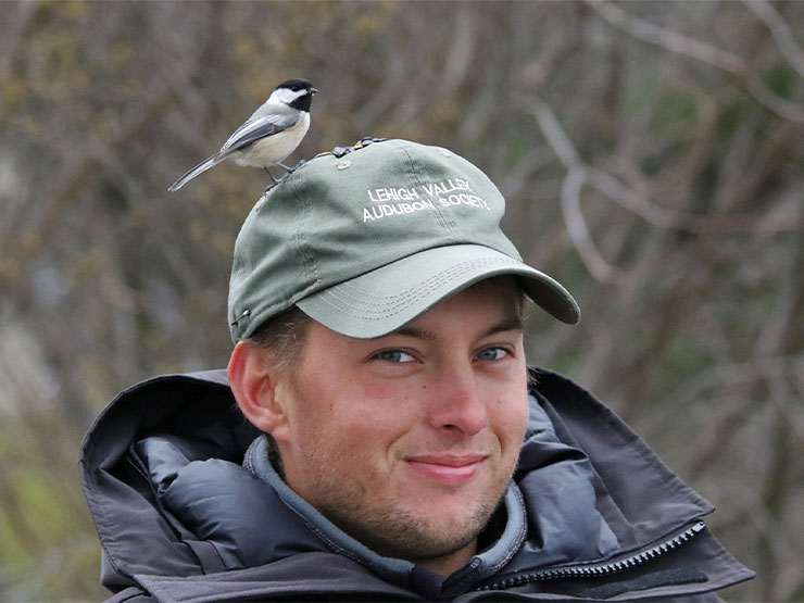 A young person wearing a hat that says Lehigh Valley Audubon Society with a bird perched on top.