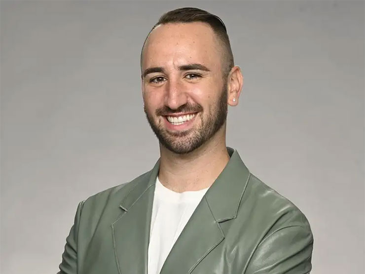 A headshot of an adult wearing a olive leather jacket.