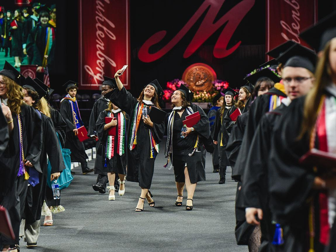 students walking down isle at commencement
