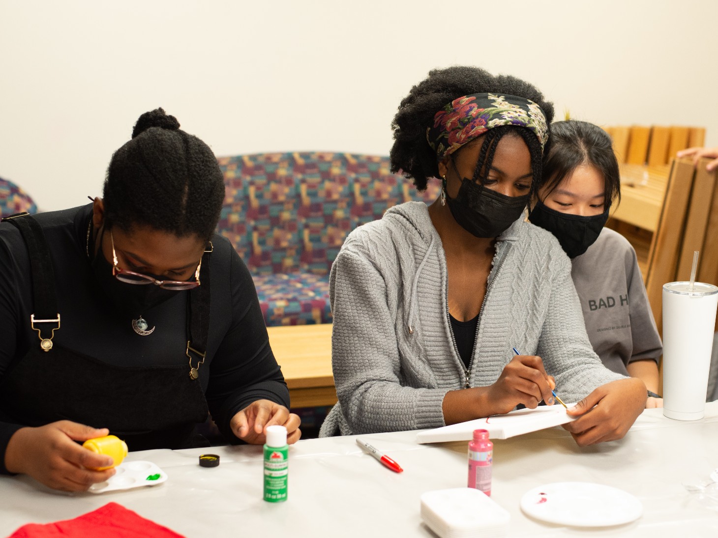Members of the Global Corner Roommate Program, Harriet Komlatse '25, Esther Oko '25 and Quynh Do  '25, decorate the student lounge in Prosser Hall.