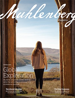 A woman stands in a doorway overlooking a scenic vista on the cover of a magzine.