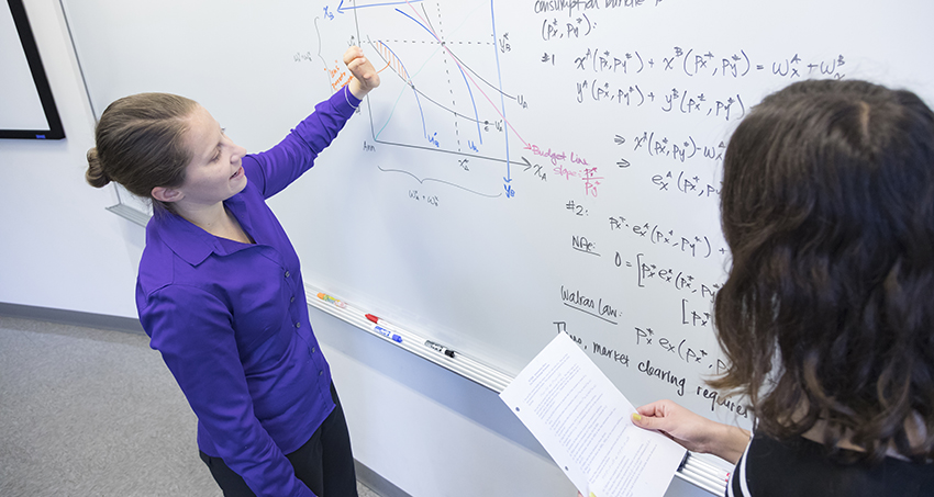 Lindsey Nagy - Economics faculty at a whiteboard