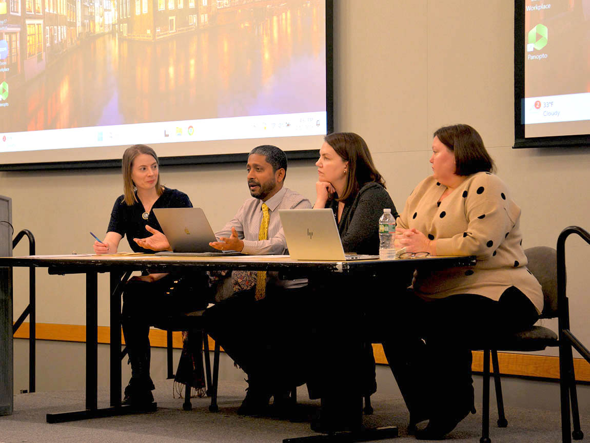 A panel of four college faculty members at table