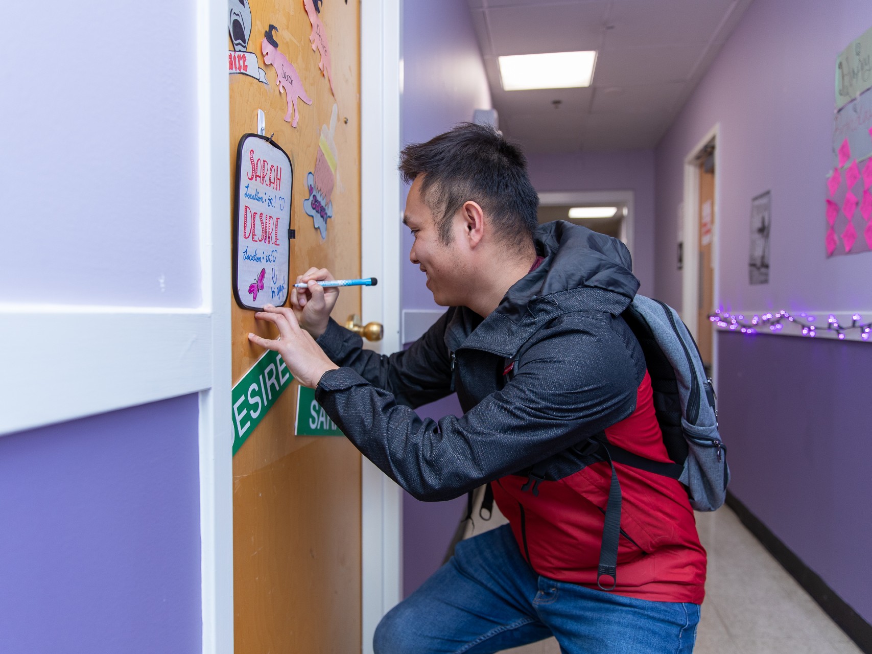 A student writes a message for a friend in one of the College's residence halls.